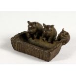 A JAPANESE BRONZE MODEL OF THREE PIGS AT A TROUGH. 2ins long.