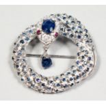 A SILVER SAPPHIRE AND RUBY EYE SNAKE BROOCH.