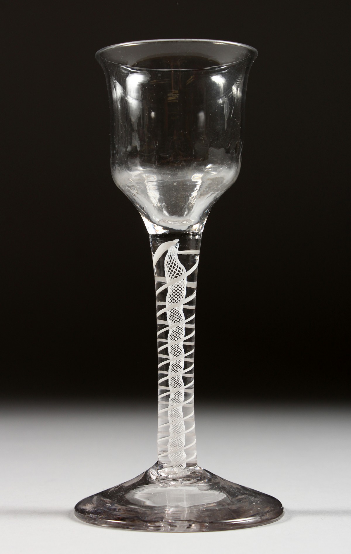 A GEORGIAN WINE GLASS with semi fluted bowl and white twist stem. 5.5ins high.