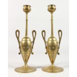 A PAIR OF CLASSICAL GREEK STYLE TWO HANDLED BRASS URN SHAPED CANDLESTICKS. 6.5ins high.