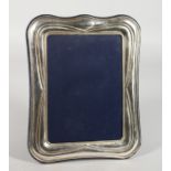 A SILVER PHOTOGRPH FRAME with shaped border. 9.5ins x 7ins.