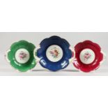 THREE FLORAL DECORATED COALPORT TWIN HANDLED PORCELAIN DISHES. One 9ins wide, two 8.5ins wide.