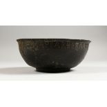 A BYZANTINE BRONZE BOWL, the rim with incised inscription. 7ins diameter.