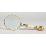 A LARGE MAGNIFYING GLASS with brass and mother-of-pearl handle.