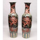 AN IMPRESSIVE PAIR OF CHINESE PORCELAIN FLOOR STANDING VASES, black ground, painted with dragons.