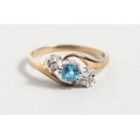 A 9CT YELLOW GOLD, DIAMOND AND BLUE STONE CROSSOVER RING.
