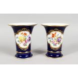 A GOOD PAIR OF MEISSEN PORCELAIN BLUE GROUND TRUMPET VASES, edged in gilt and painted with a panel