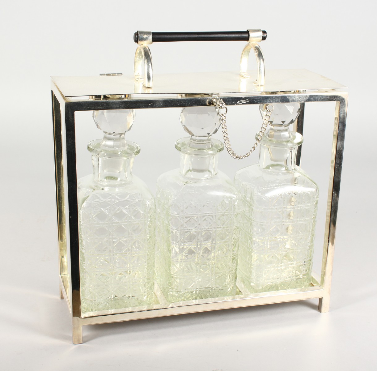 A CHRISTOPHER DRESSER DESIGN THREE BOTTLE TANTALUS with three cut glass whisky decanters and