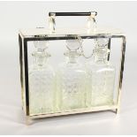 A CHRISTOPHER DRESSER DESIGN THREE BOTTLE TANTALUS with three cut glass whisky decanters and