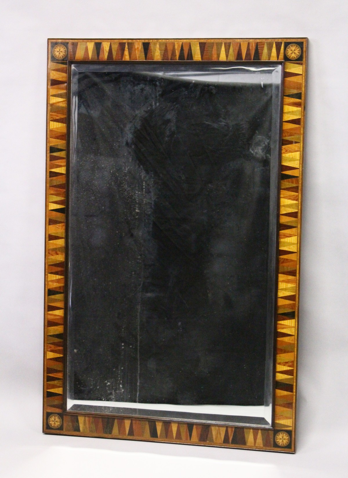 A REGENCY DESIGN RECTANGULAR MIRROR, with specimen wood sectional frame, the corners with an