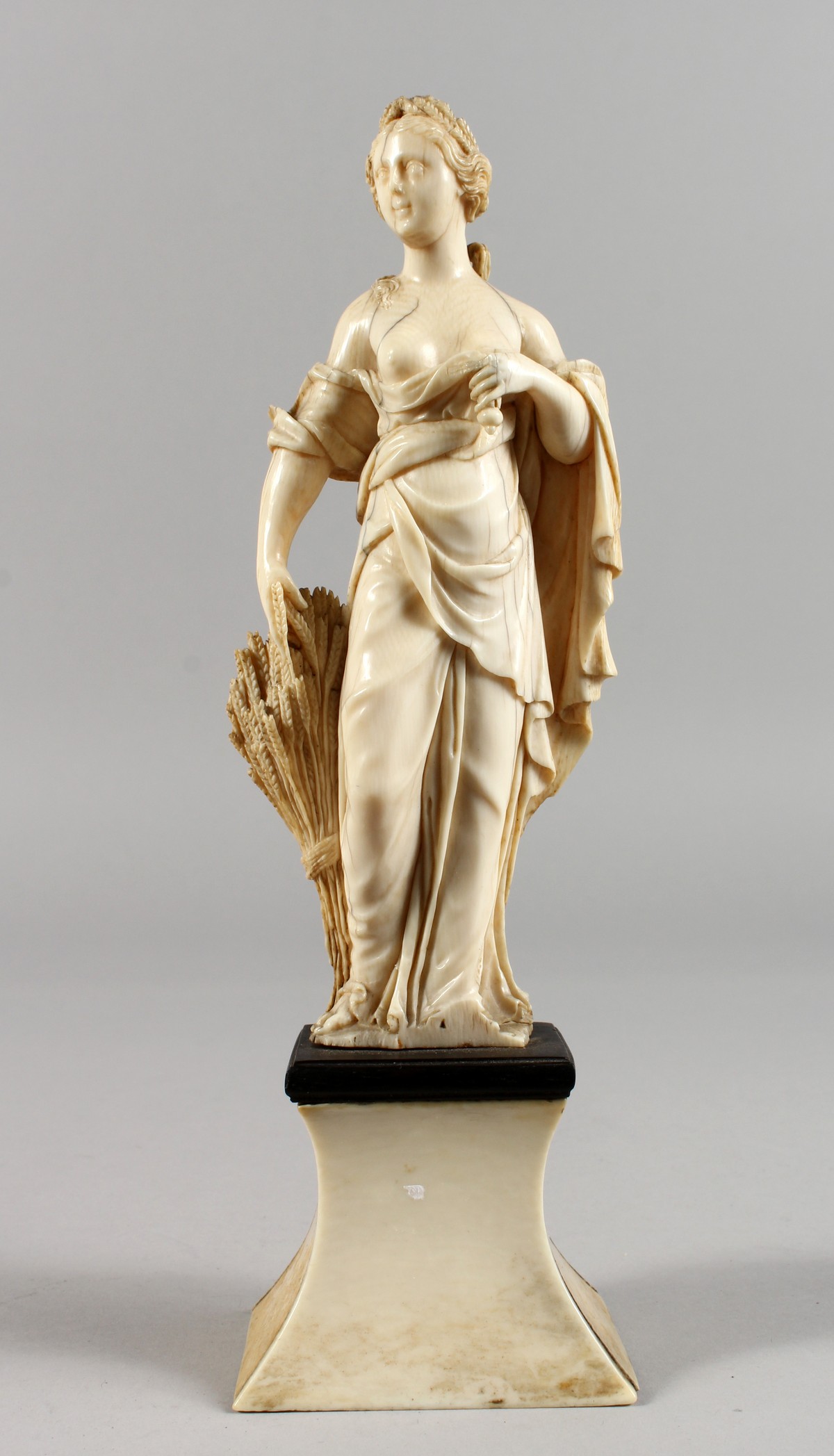 AN 18TH CENTURY CARVED IVORY FIGURE OF A YOUNG FEMALE FIGURE depicting AUTUMN, standing on a plinth. - Image 5 of 5