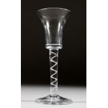 A GEORGIAN WINE GLASS with inverted plain bell shaped bowl and air twist stem. 6ins high.