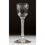 A GEORGIAN WINE GLASS, the bowl engraved with flowers and bird, with white air twist stem. 5.75ins