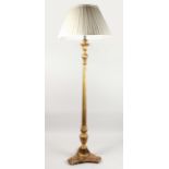 A GILTWOOD STANDARD LAMP, with carved and fluted decoration, on a concave sided base with cream