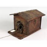 A VERY GOOD BLACK FOREST CARVED WOOD DOG IN A KENNEL SMOKING COMPACTUM, the roof of the dog kennel