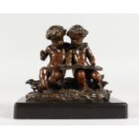 A SUPERB SMALL 19TH CENTURY BRONZE OF TWO PUTTI reading a book on a metal base. 4.5ins wide.