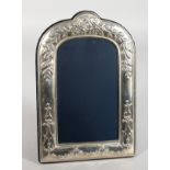 A SILVER PHOTOGRAPH FRAME, arched top repousse with flowers. 10ins x 6ins.