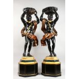 A GOOD PAIR OF CARVED WOOD AND PAINTED BLACKAMOOR FIGURES ON STANDS, each depicting a male figure