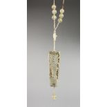 AN UNUSUAL GOLD MOUNTED CHINESE PIERCED JADE PENDANT, on a beaded cord necklace. Plaque 3ins long.