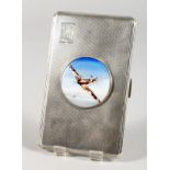 A LARGE ENGINE TURNED SILVER CIGARETTE CASE with a circular enamel plaque of a Spitfire.