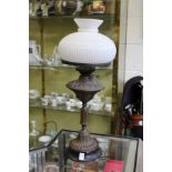 A Victorian copper oil lamp with opaque glass shade.
