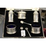 A cased silver five piece condiment set with spoons.