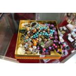 A decorative box containing numerous costume necklaces.