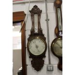 A carved oak barometer / thermometer.