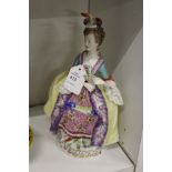 A continental porcelain figure of a lady carrying a fan.