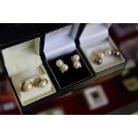 Three pairs of pearl earrings.