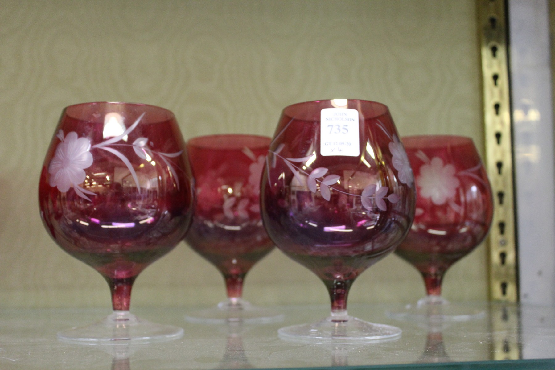 A set of four etched ruby glass brandy balloons.