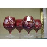 A set of four etched ruby glass brandy balloons.