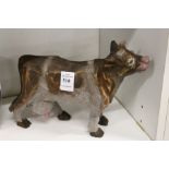 A carved and painted wooden model of a cow.