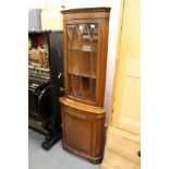 A mahogany standing corner cabinet.