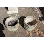 A pair of reconstituted stone garden pots.