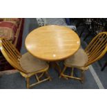 A small circular kitchen table and two chairs.