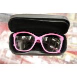 A pair of Dolce and Gabbana pink sunglasses, boxed.