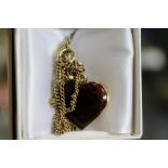 A gold and hardstone heart shaped pendant and chain.