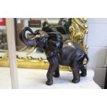 A large continental bronze glazed pottery model of a bull elephant.