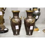 A pair of spelter twin handled vases decorated with lizards.