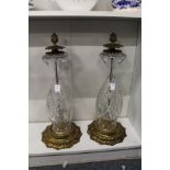 A large pair of cut glass and brass lamp bases.