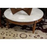 A circular marble top coffee table on tapering square legs.
