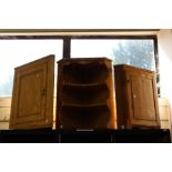 A pine corner cupboard and similar cupboard with shelves.