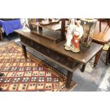 AN 18TH CENTURY SPANISH OAK SERVING TABLE with a single plank top, three carved frieze drawers on