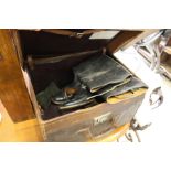 An old leather trunk containing a pair of leather riding boots.