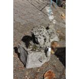 A garden ornament modelled as a girl lying down reading a book.