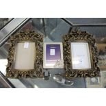 A pair of decorative photograph frames and another frame.
