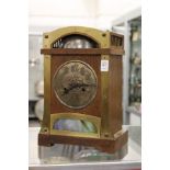 An oak cased Arts & Crafts mantle clock made for Liberty's, with a domed top case, exposed bell,