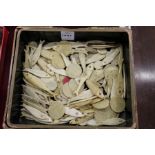 A quantity of Chinese bone fish shaped and other counters in a lacquer box.