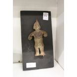 A small eastern pottery figure mounted on a board.